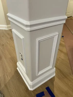 White painted kitchen island cabinet with raised panel doors and crown molding detail