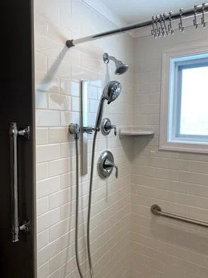 White subway tile shower with chrome rainfall showerhead, handheld sprayer, and multiple body jets