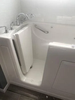 White walk-in bathtub with grab bars, low-entry door, and chrome fixtures