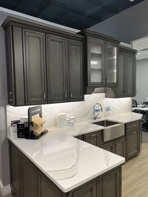 Gray shaker cabinets with white quartz countertops and stainless steel sink
