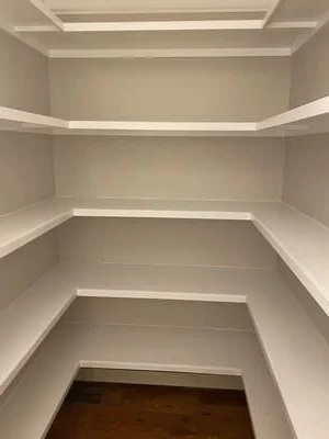White built-in shelving with LED lighting and coffered ceiling detail