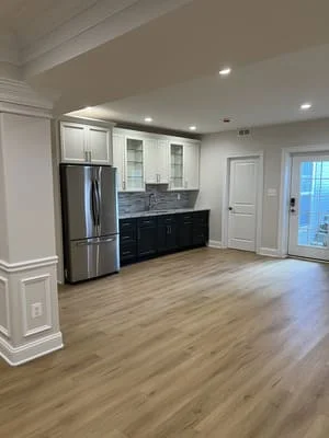 Modern kitchen with white and dark cabinetry, stainless steel appliances, recessed lighting, and vinyl plank flooring