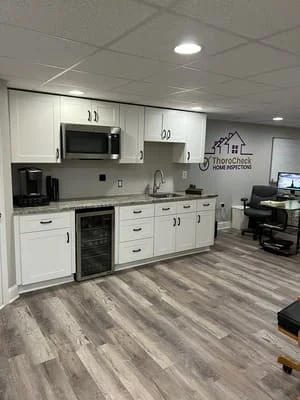 White kitchen cabinets, stainless steel appliances, gray vinyl plank flooring, recessed lighting